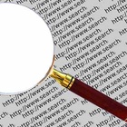Suchmaschinen zeigen Ergebnisse aus den unterschiedlichsten Quellen an. Text im Hintergrund, im Vordergrund eine Lupe